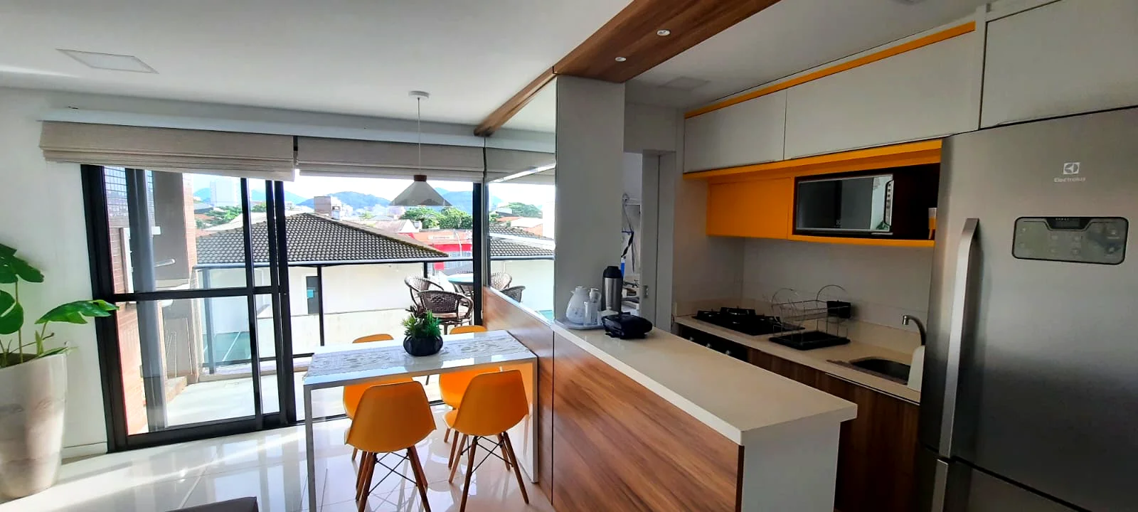 Vista da sala integrada com cozinha e sacada